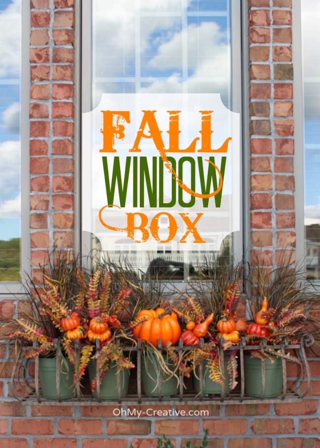 fall window box with pumpkins and fall silk greens 