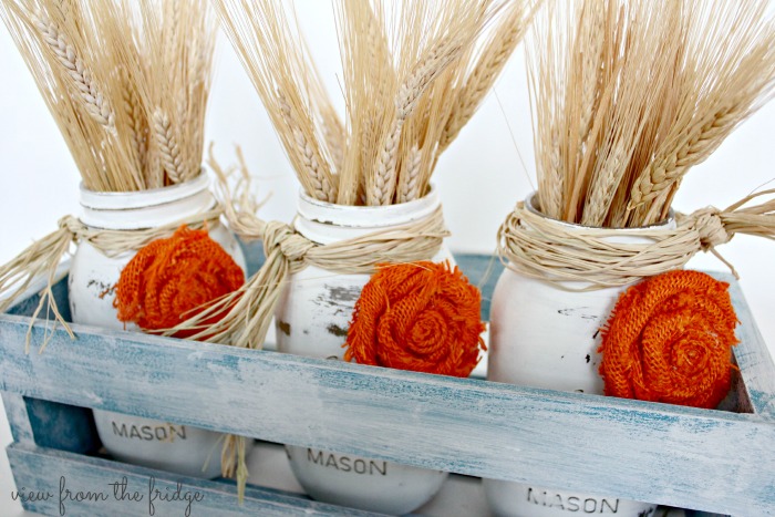 This Easy Fall DIY Centerpiece is a perfect Fall decor accent for the home. OHMY-CREATIVE.COM | Fall Decor | Mason Jar Centerpiece | Fall Mason Jar Craft | Fall Decorating | Painted Mason Jars | How to make a rosette | Wheat Fall decor | How to decorate for Fall | Crate Decor | Fall Mason Jar Decor | Fall Home Decor | Mason Jar Centerpieces