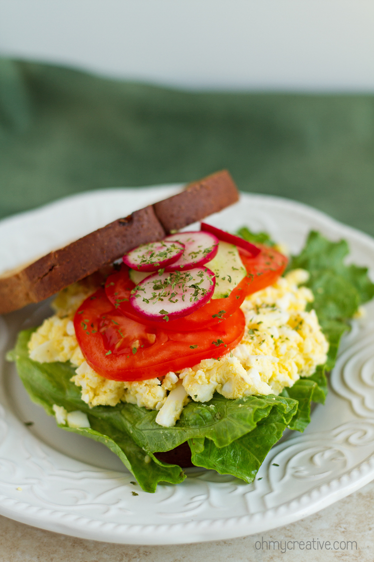 An egg salad sandwich with tomatoes and lettuce