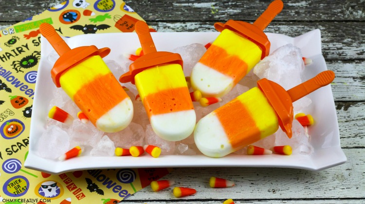 Yogurt Candy Corn Popsicle! Yellow, orange and white popsicles |  OHMY-CREATIVE.COM | Candy Corn Dessert Recipes | recipes using candy corn | Homemade candy corn | Halloween Treat | Halloween Dessert |  Ideas for candy corn