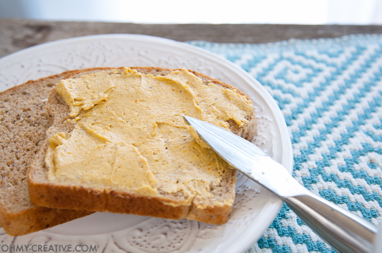A knife spreading pumpkin butter on two pieces of toast 