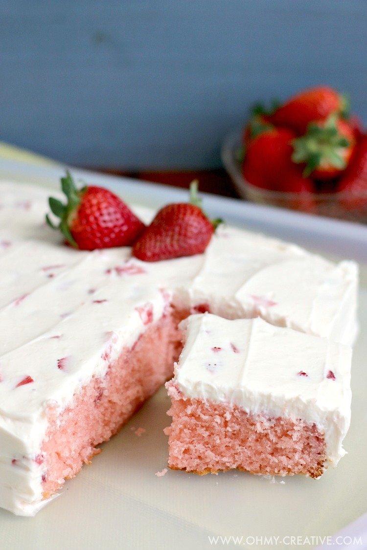 This Strawberry Cake With Whipped Cream Cheese Frosting is bursting with fresh strawberry flavor. A perfect dessert for any occasion spring or summer. OHMY-CREATIVE.COM | strawberry sheet cake | strawberry cake from scratch | homemade strawberry cake | fresh strawberry cake | whipped cream cheese frosting | spring dessert | summer dessert | dessert recipe | fresh strawberries | sheet cake recipe | 