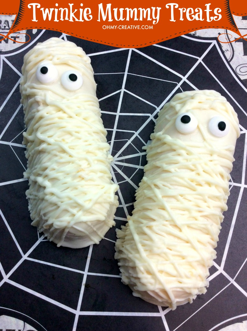 Twinkie Mummy cakes for Halloween Treats displayed on a spiderweb background