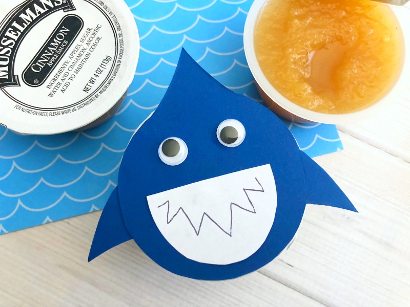 These Shark Applesauce Cups are a fun Shark Party Food or shark craft for kids. Great for Shark Week too! Shark Party | Shark Craft | Shark Food | Applesauce Cups | Applesauce | Shark Party Ideas #sharkweek #sharkparty #sharkpartyfood #applesaucecups 