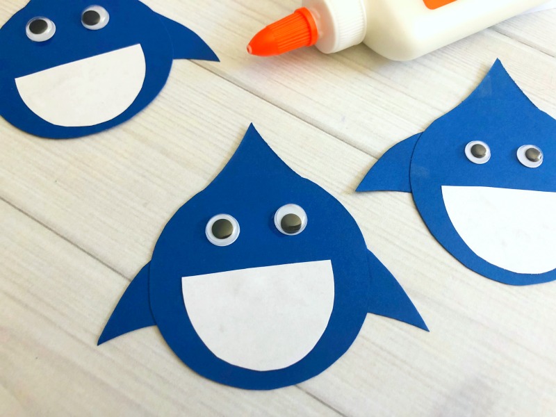 Glue white pieces of paper to the blue sharks and add googly eyes. 