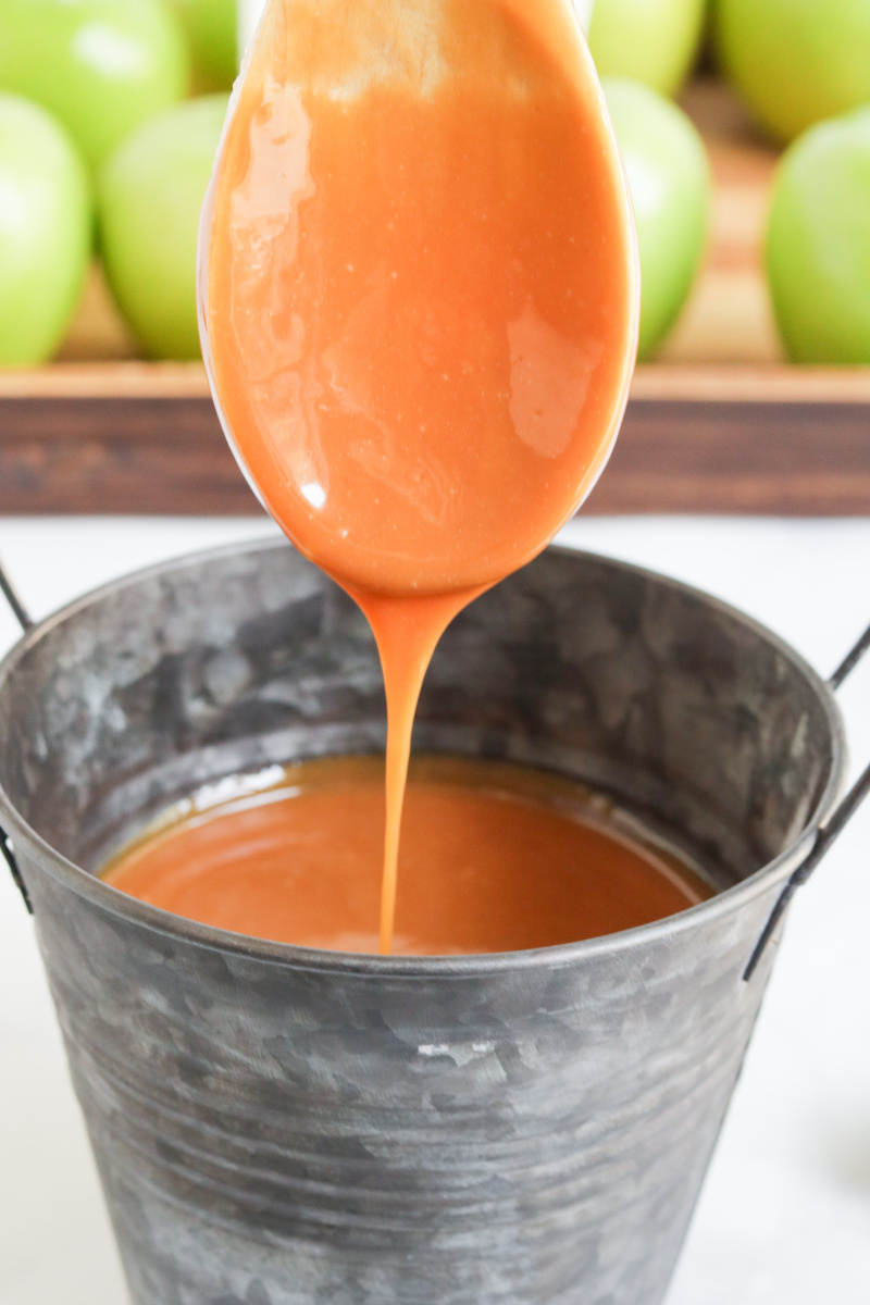 wooden spoon with caramel sauce dripping from the spoon