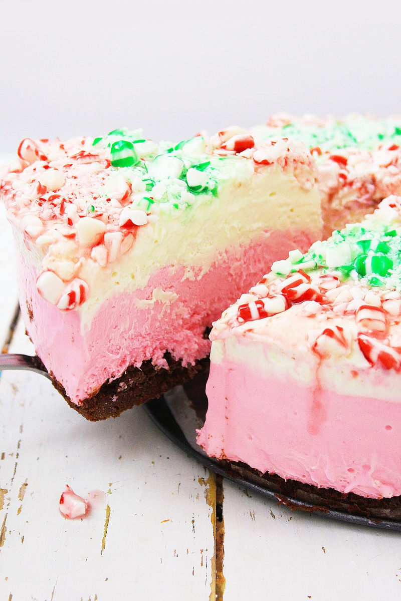Serve a slice of this no bake peppermint cheesecake to family and friends this holiday season. Slice being served with a pie server.