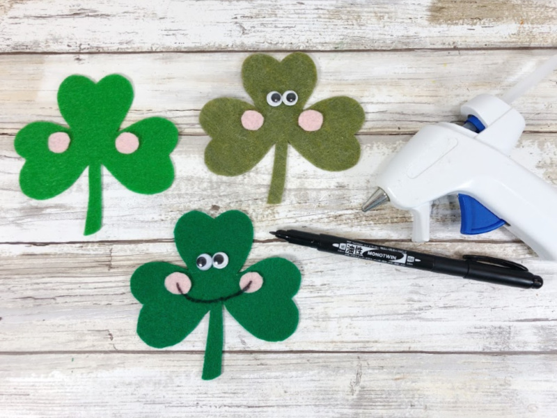 Attach wiggle eyes with glue or glue sticks to the top center of the Shamrock, placing them right beside each other.