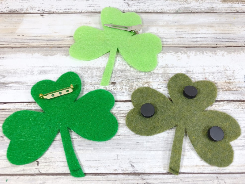 Finished felt shamrock craft with smiling faces and googly eyes. Options to add pin or magnet backing to shamrocks.