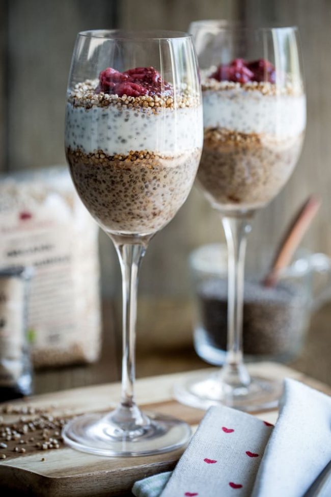PB&J chia pudding served in wine glasses sitting on a cloth napkin.