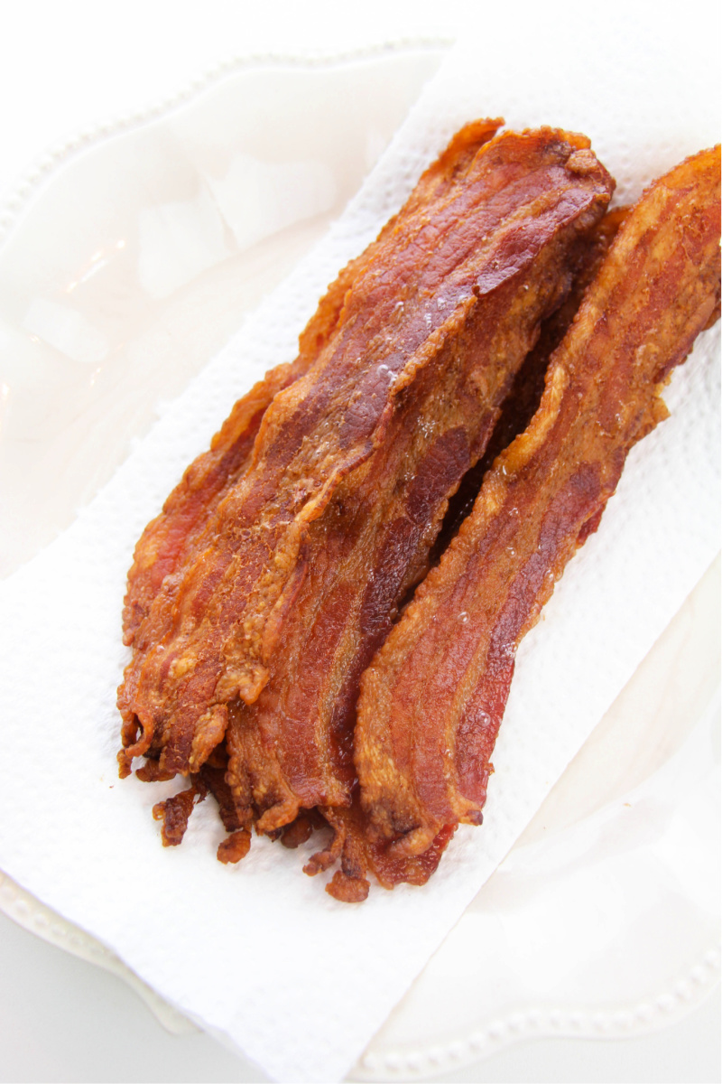 Crispy bacon placed on a paper towel to absorb extra bacon grease.