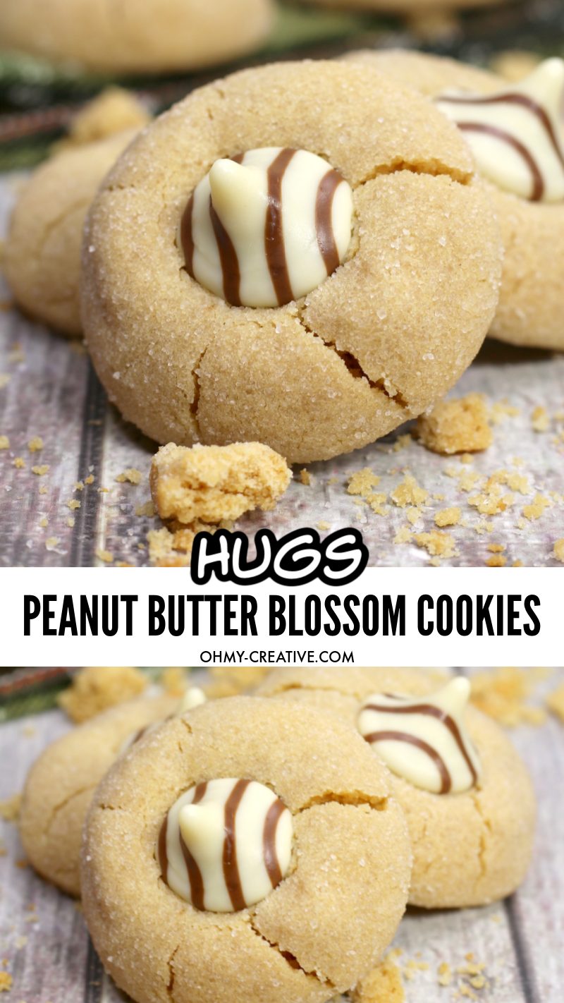 Peanut butter blossom cookies made with Hershey Hugs Kisses on a wood plank background. A try of cookies is seen in the background.