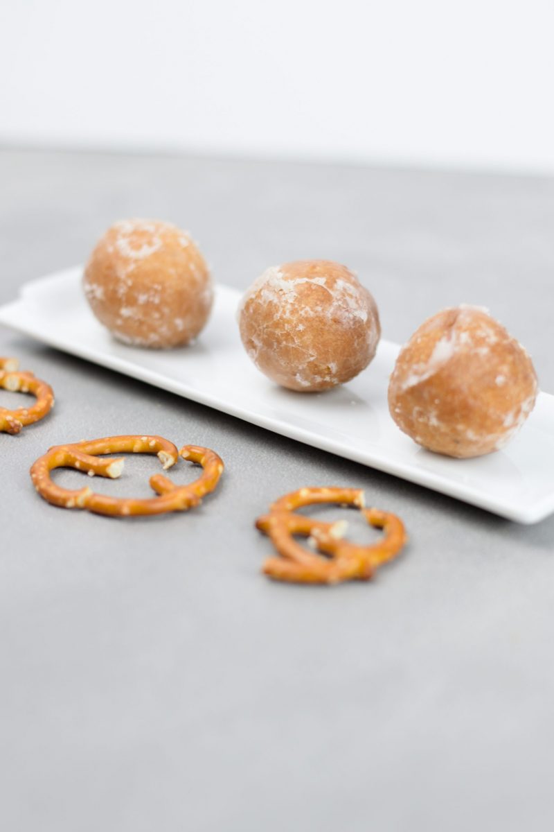 The donut holes are placed on the white platter with the pretzel haves ready to be use as the reindeer antlers.