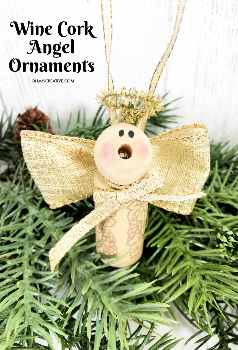 A finished wine cork angel displayed on some evergreen garland.
