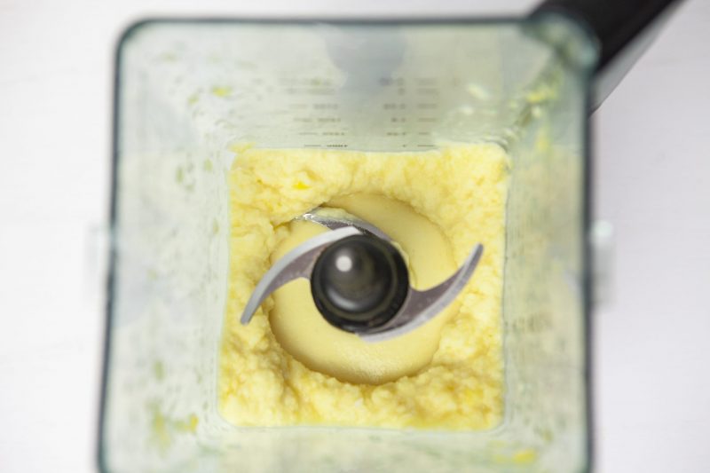 Looking inside the blender as the frozen Dole pineapple is starting to be blended with the almond milk and is creamy smooth.