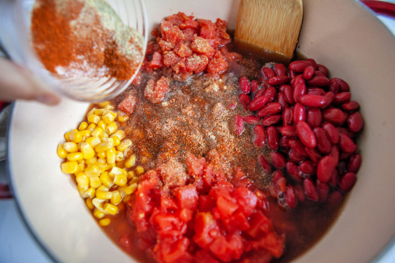 Vegetables, beans and corn are added to the stock pot to simmer together on the stove. 