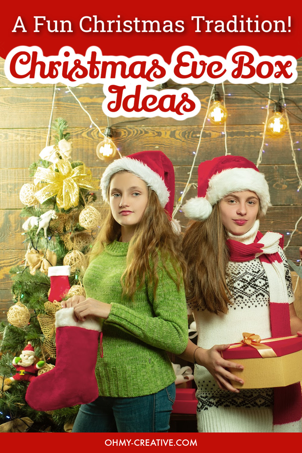 Two teens standing in front of a Christmas tree holding a Christmas Eve Box gift.