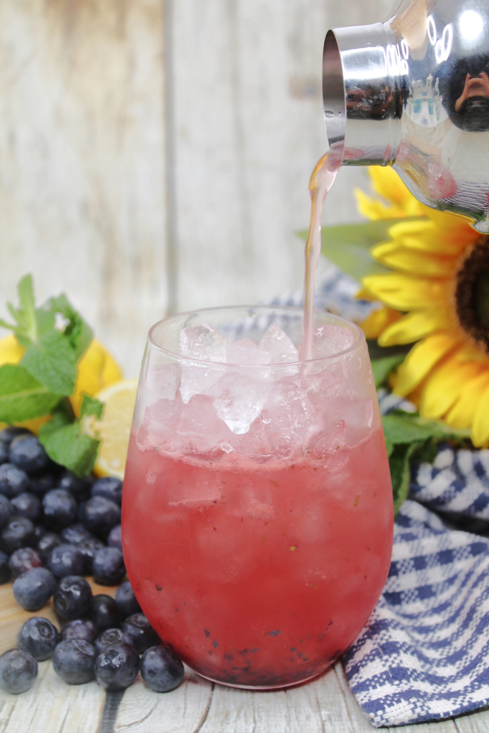 Once the blueberry puree and ice are added to the glass, top with rum and soda water.