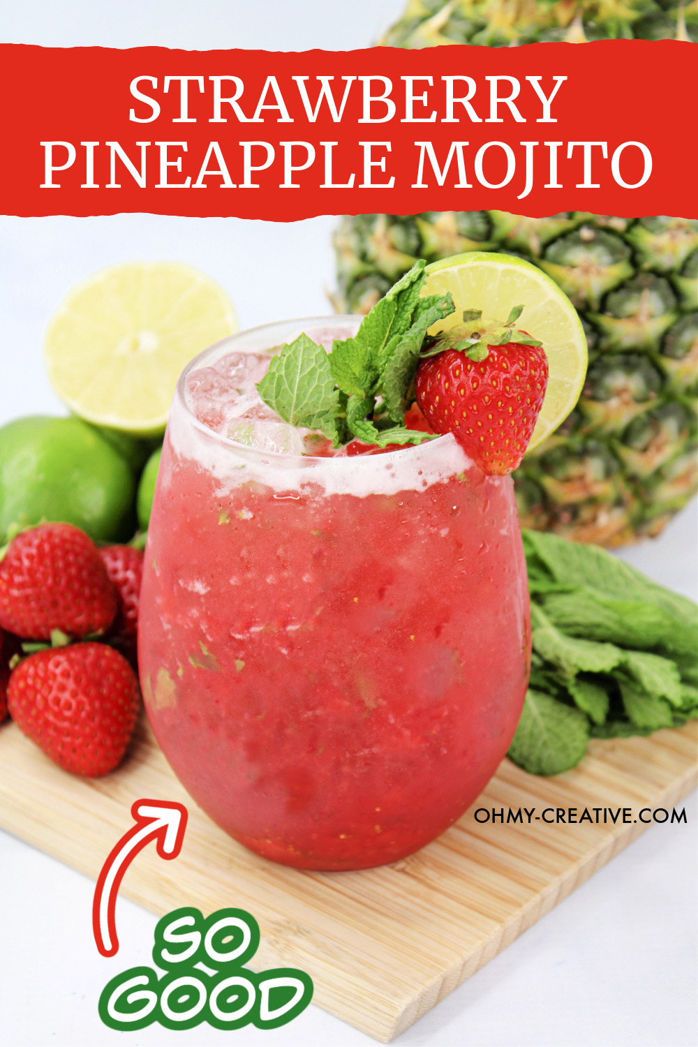 This Strawberry Pineapple Mojito cocktail is garnished with strawberry and mint. It is sitting on a wooden cutting board surrounded by strawberries, limes and a whole pineapple.