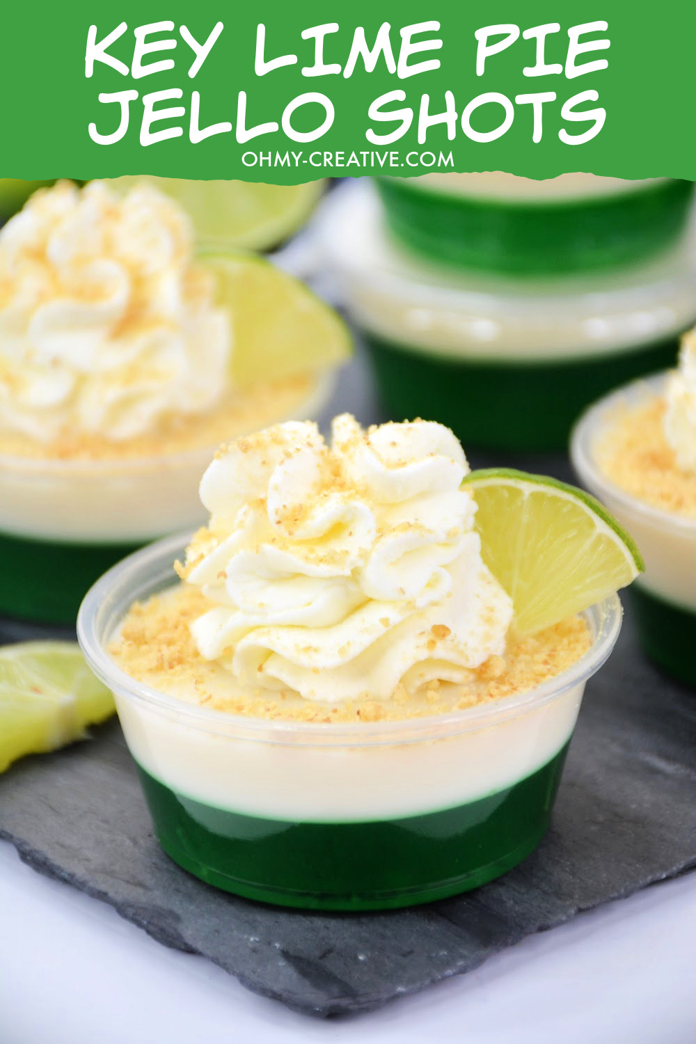 These Key Lime Pie Jello Shots have a layer of lime Jell-o and a layer of creamy key lime pie filling topped with whipped cream and a sprinkle of gram cracker and a lime wedge. 