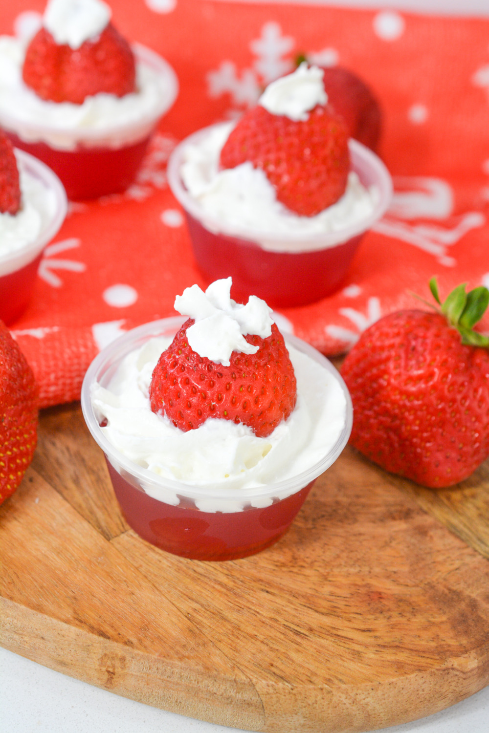 Whip up these Santa Hat Jello Shots using strawberry Jell-O, strawberries and whipped cream - a tasty strawberry jello shot recipe.