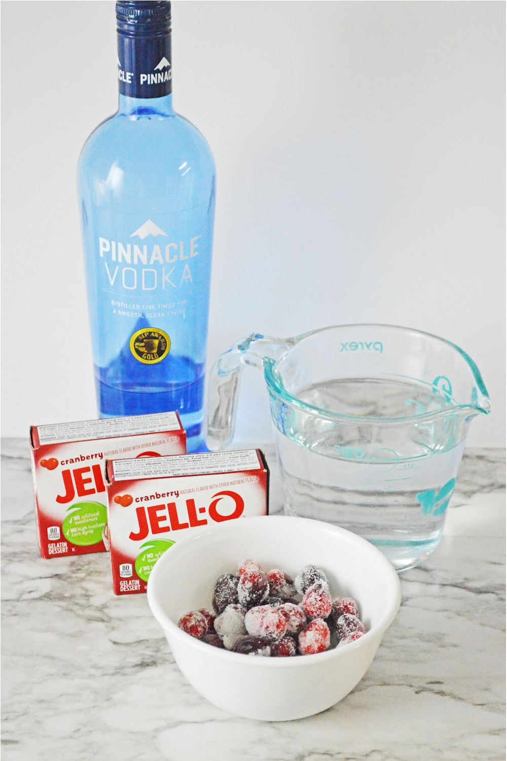 Ingredients for Cranberry jello Shot recipe including cranberry jell-o, vodka and sugar coated cranberry garnish.