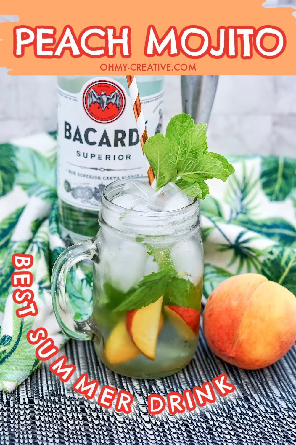 peach mojito cocktail surrounded by fresh peaches served in a mason jar and a bottle of bacardi rum in the background.