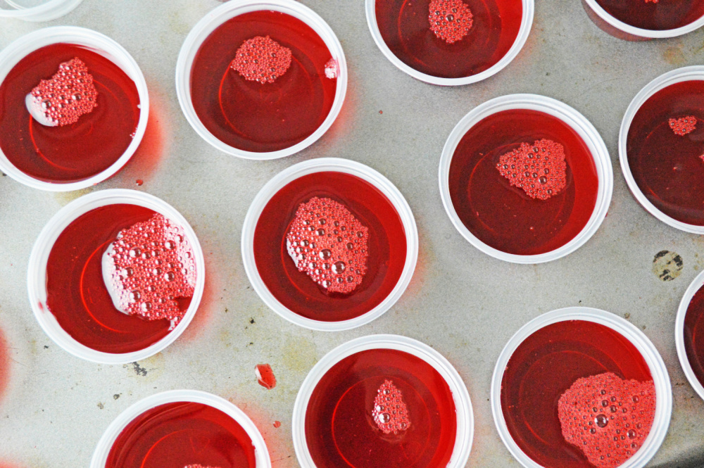 A tray of cranberry jello shots setting up.