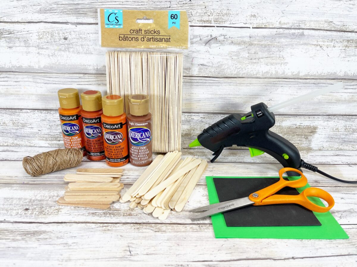 Supplies you'll need in order to make popsicle stick pumpkins.