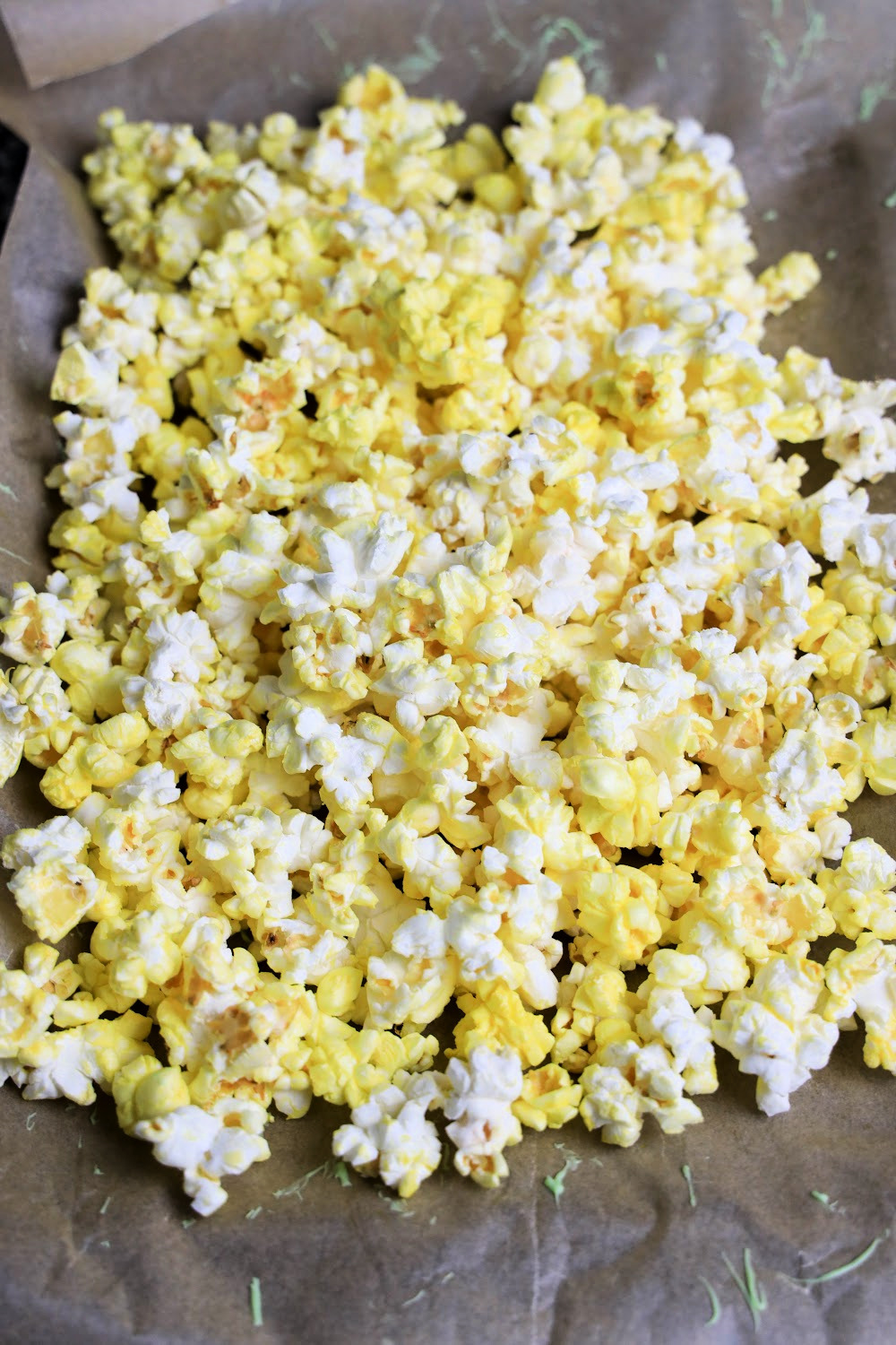 Make some buttered popcorn and remove all the unpopped kernels. Then, place the popped ones on a baking sheet that is covered with parchment paper.