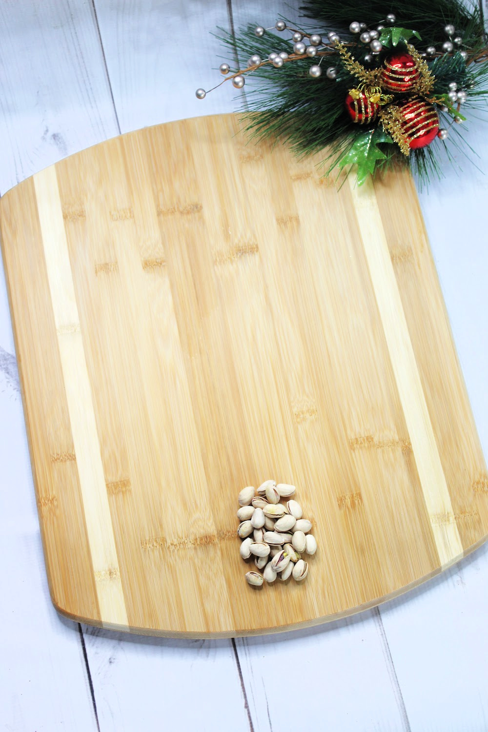 An empty charcuterie board using nuts as the trunk of a Christmas tree.