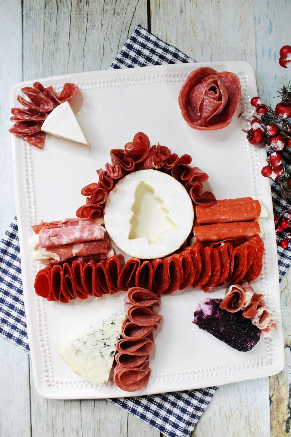 For the Christmas charcuterie board, place the Christmas tree brie in middle and then add the meats around it.