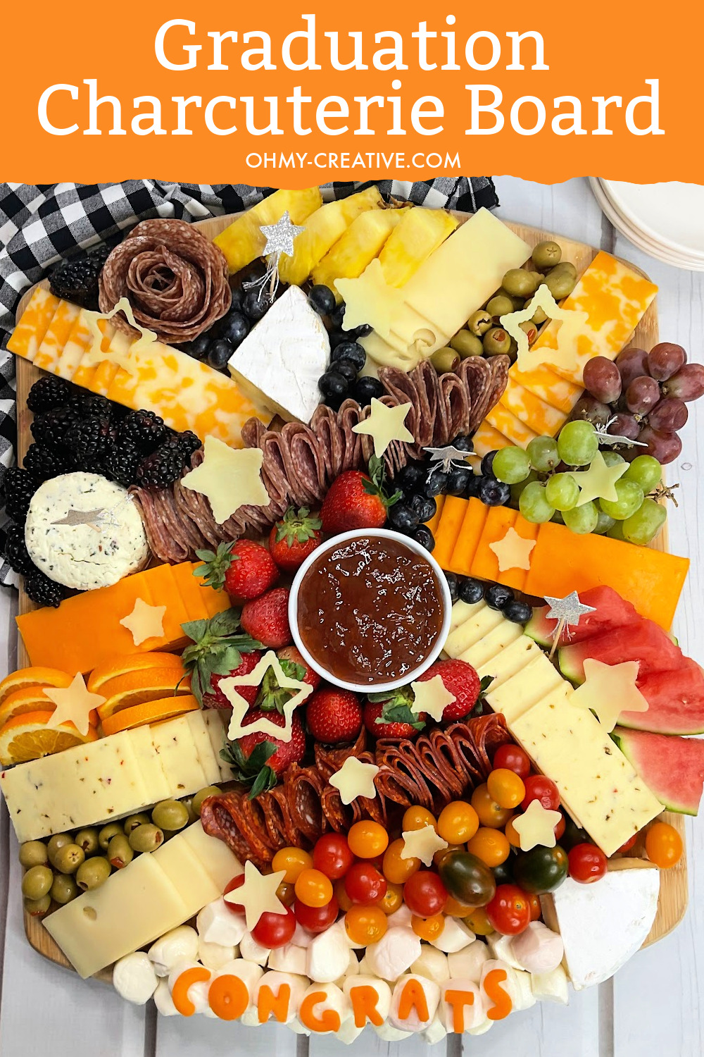 The ultimate graduation party foods - graduation party charcuterie board with the congrats made out of cheeses and jams and dips.