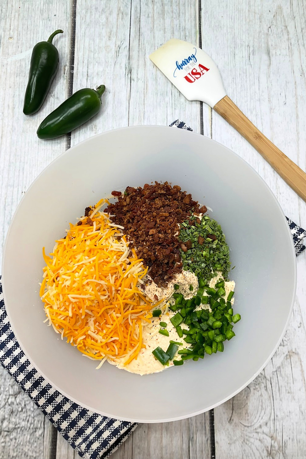 Add all the ingredients to the football cheese ball into a mixing bowl and combine.