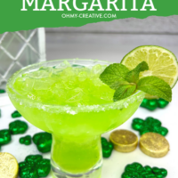 Pin image with a green Irish margarita in a margarita glass garnished with a lime. In the background are shamrocks and gold pieces.