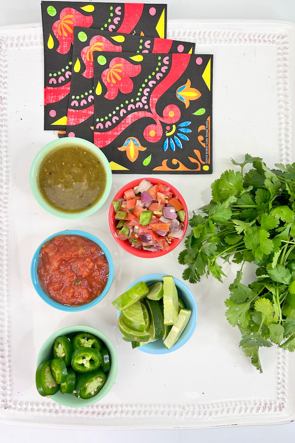 Small bowls of Mexican salsas, dips and peppers.