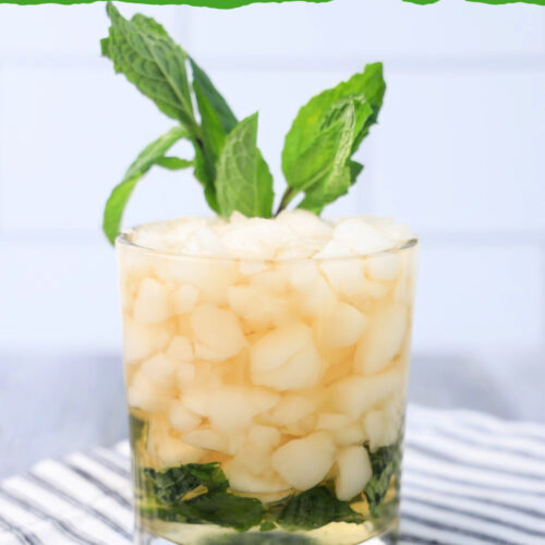 A 3 ingredient mint julep cocktail made with Kentucky bourbon on a striped napkin garnished with mint.