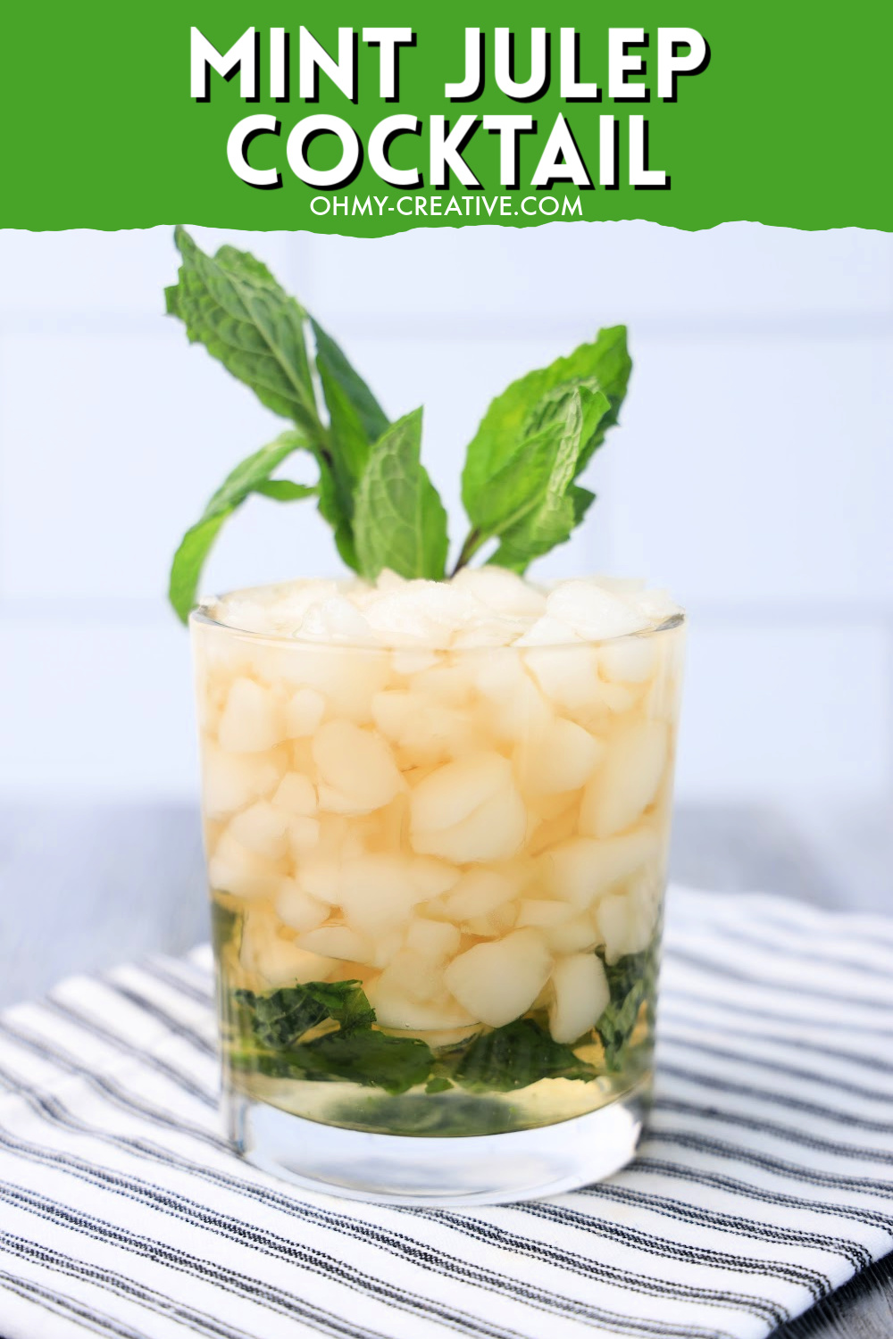 An 3 ingredient mint julep cocktail made with Kentucky bourbon on a striped napkin garnished with mint.
