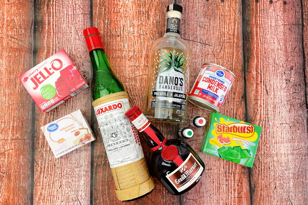 Ingredients to make a Cinco de Mayo jello shots on a wood background.