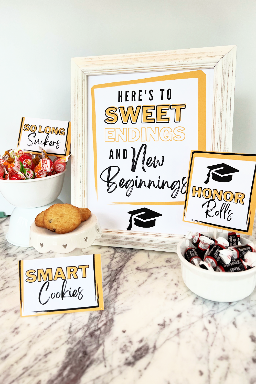 Graduation candy bar signs including a display sign that reads "Here's to sweet endings and new beginnings."