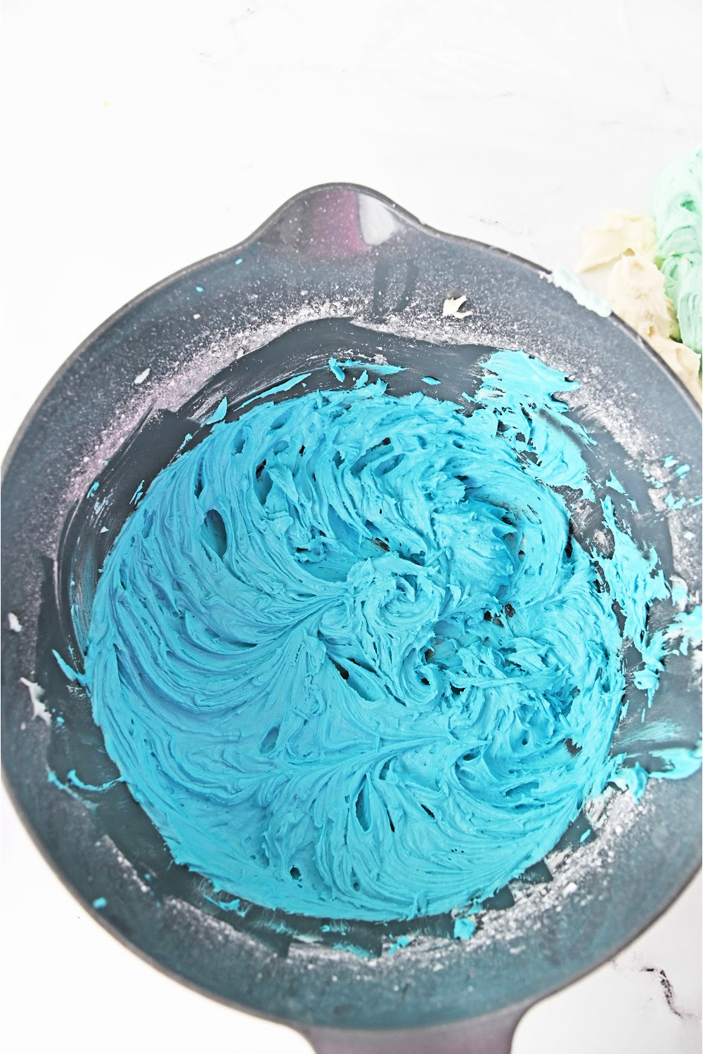 To the remaining buttercream frosting, add 3-4 drops of blue food coloring, and mix to combine.