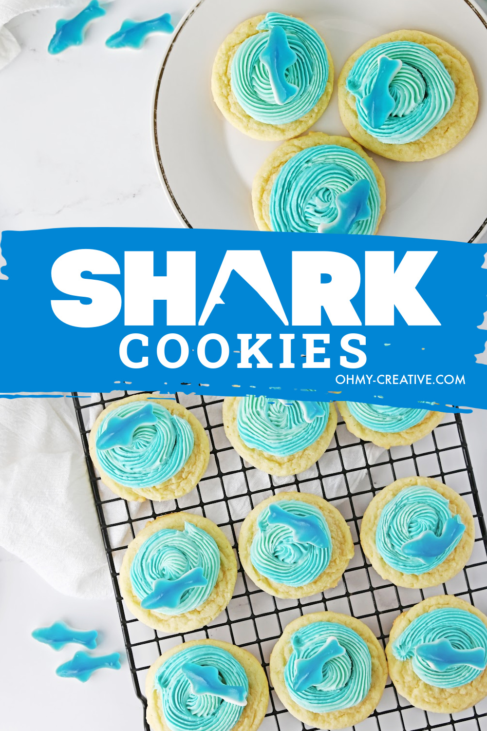 Shark cookies on a white plate and cookies on a cooling rack with blue icing and a gummy shark.