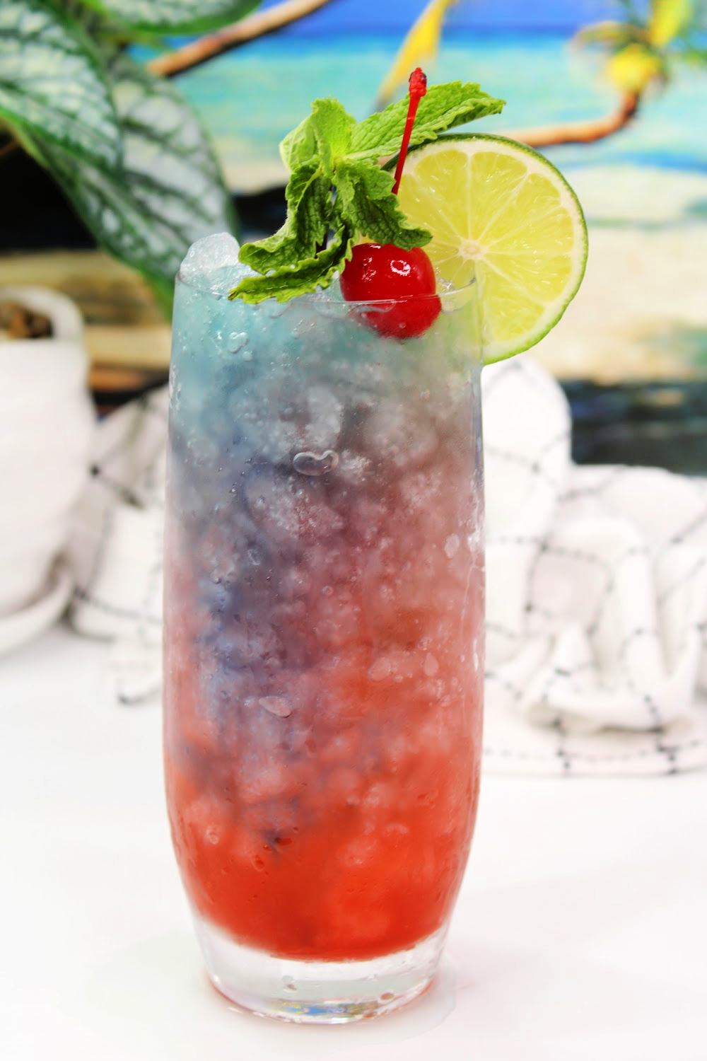 This shark bite cocktail looks like blue ocean water with grenadine added to look like blood from a shark bite.