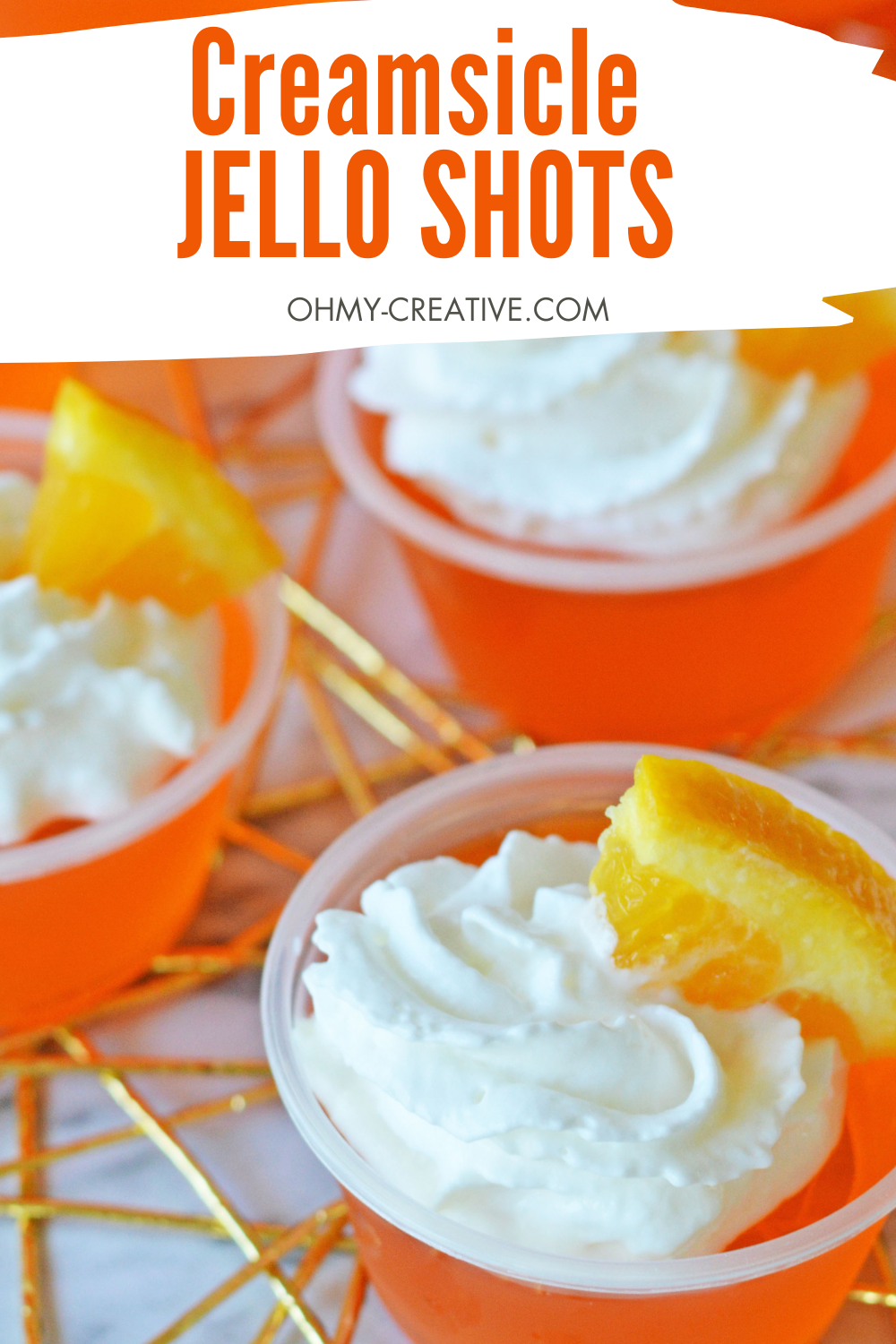  Pinterest image of creamsicle Jello shot with wiped cream and a slice of orange of for garnish.