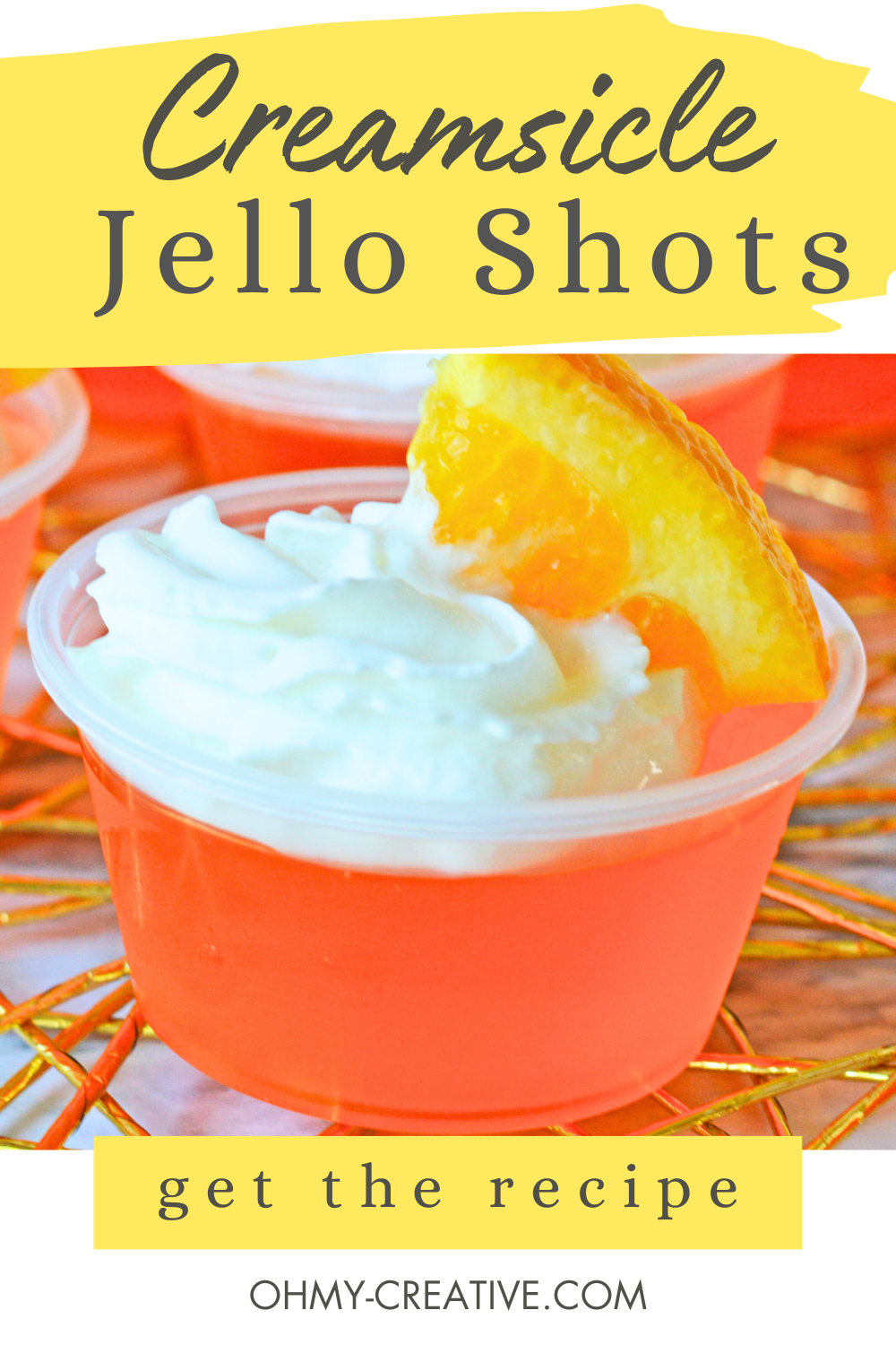Pinterest image of a single creamsicle Jello shot with wiped cream and a slice of orange of for garnish.