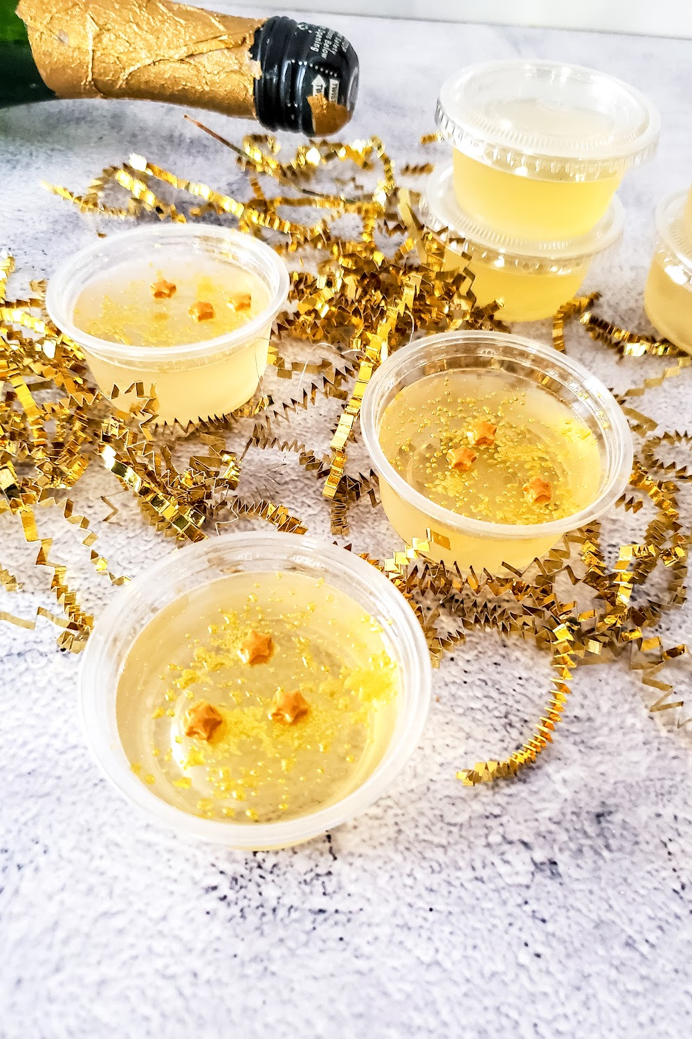 New Year's Eve gold star sprinkles on top of champagne jello shot cups.