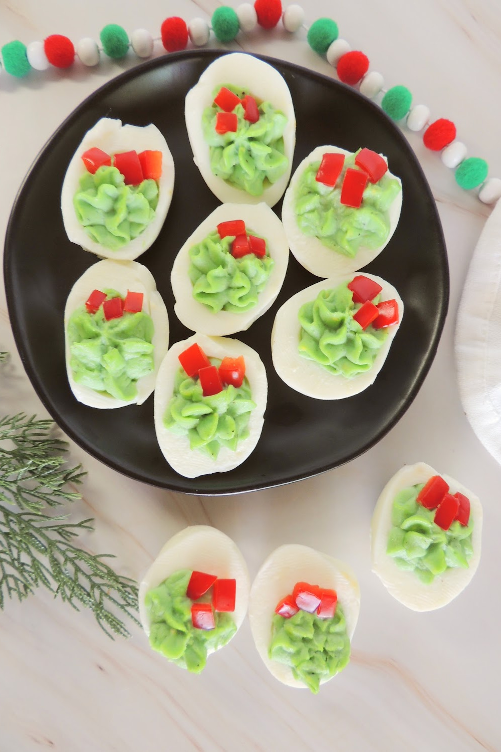A tray of Christmas deviled eggs that look like a Christmas wreath.