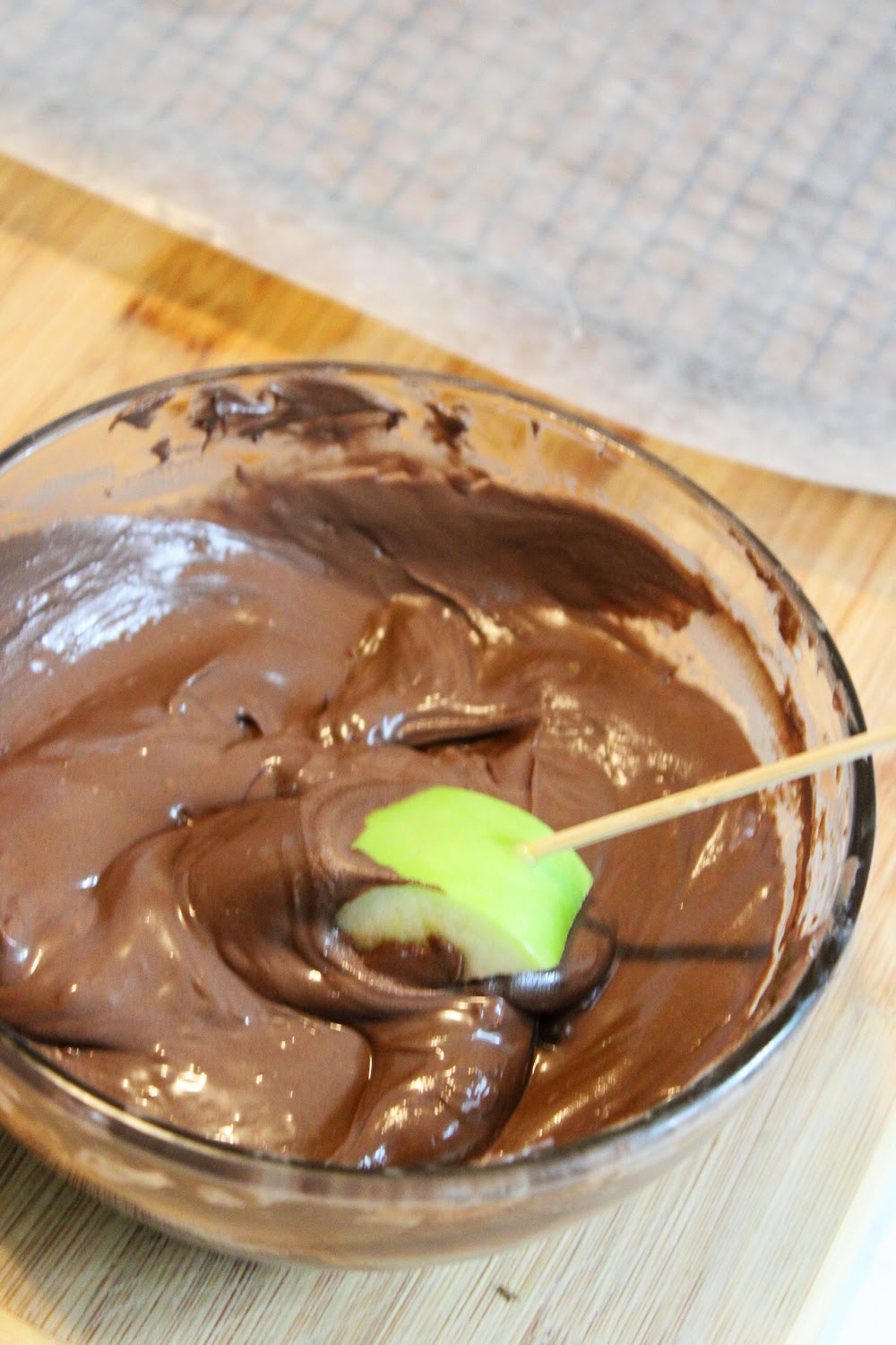 dip the apple slice into the melted chocolate.