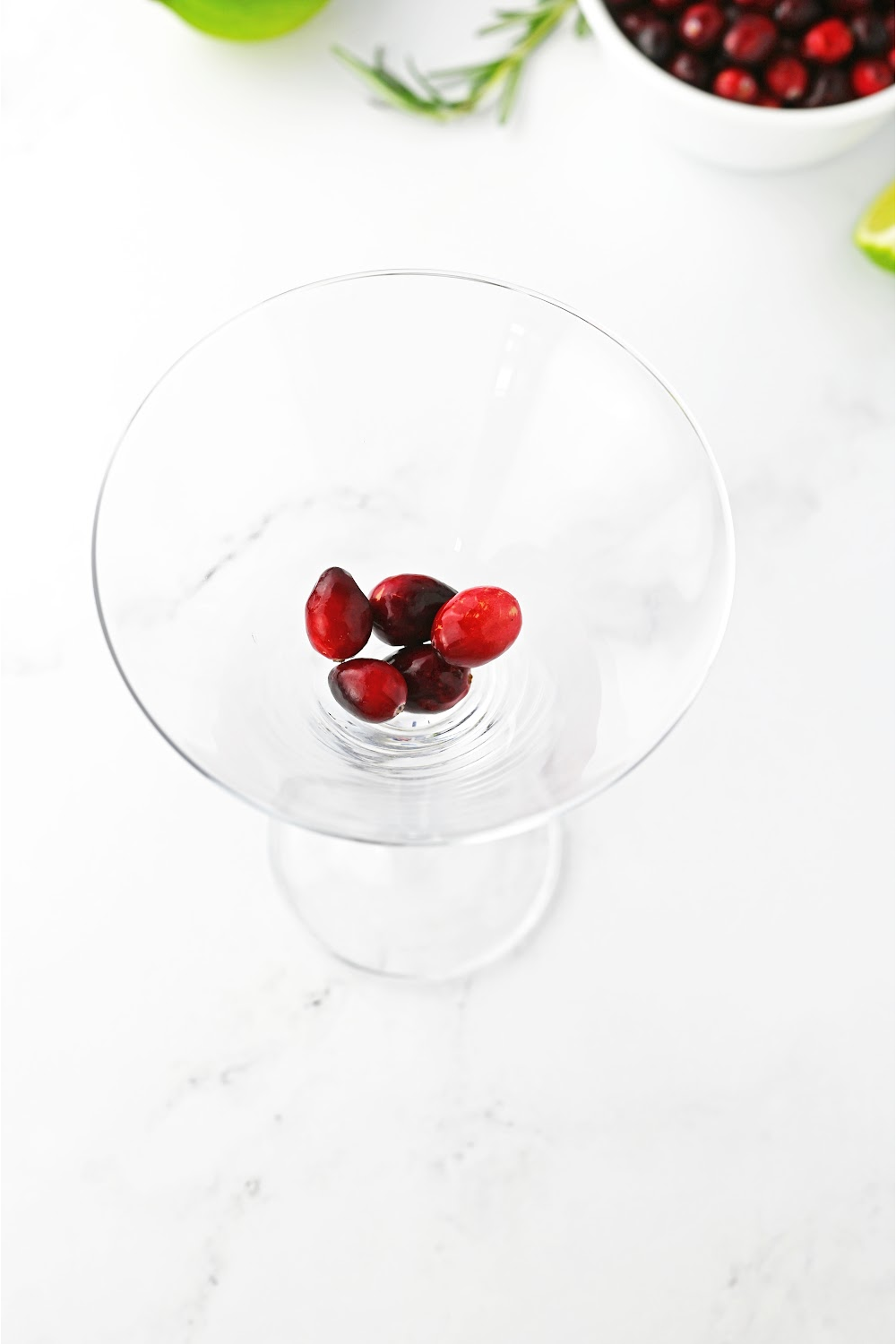 Martini glass with fresh cranberries placed in the bottom.