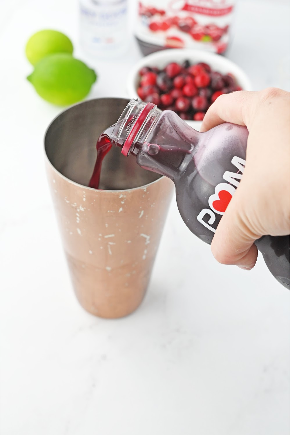 Pouring pomegranate juice into a cocktail shaker.